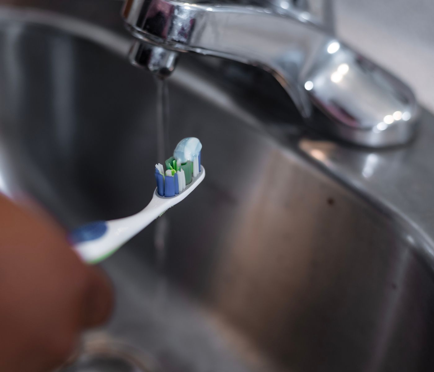 Toothbrush being rinsed for daily oral care
